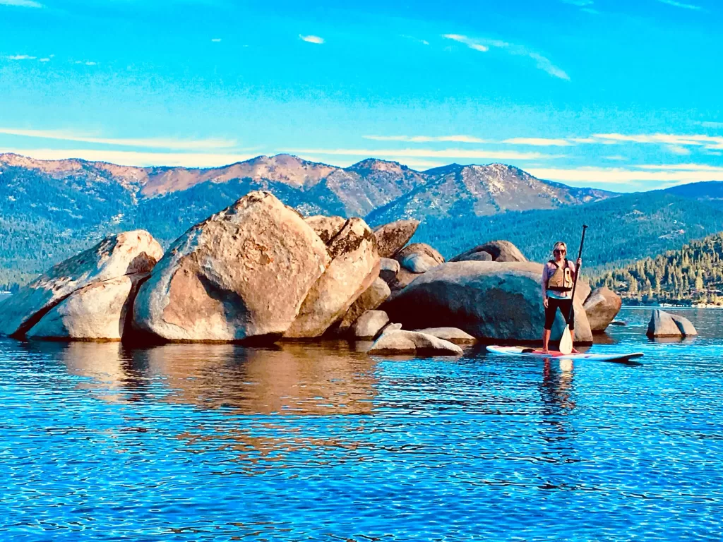 Paddleboarding near huge boulders in Lake Tahoe